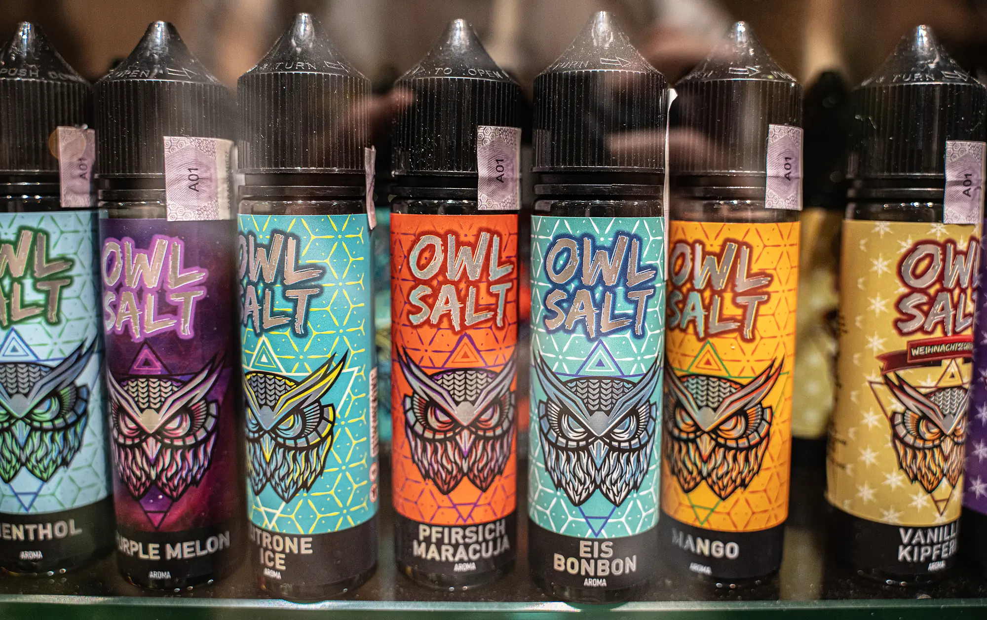 Nahaufnahme bunter Liquid-Flaschen im Regal bei SmokeFactory Köln