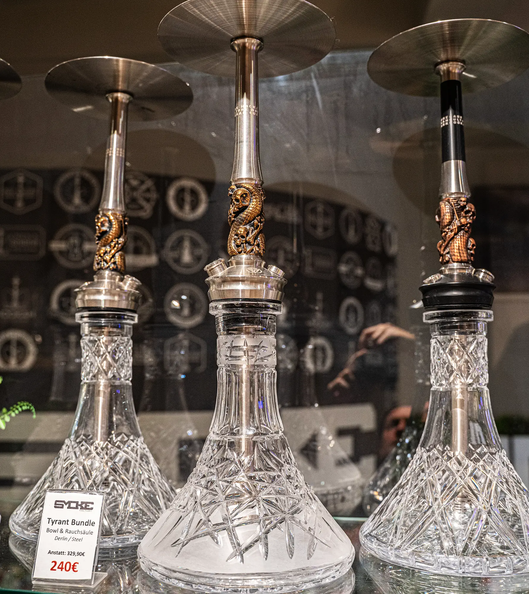 Kristall-Shishas mit goldener Drachenverzierung in der Glasvitrine bei SmokeFactory Köln
